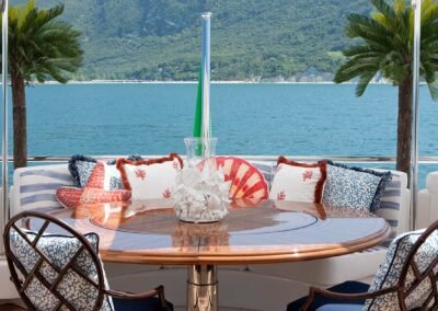 Tropical fabrics and pillows accessorize a dining space on the deck of a Patrick Knowles Designed yacht